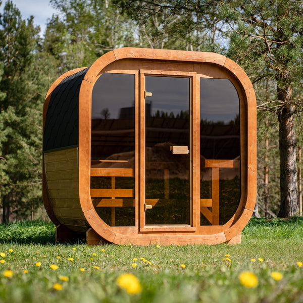 Sauna ogrodowa SAUNARI G160 w formie kubika stojąca na tarasie w ogrodzie